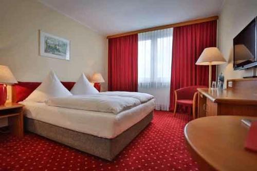 a hotel room with a large bed and a desk at Hotel Rosenstadt & Malxestube Restaurant 