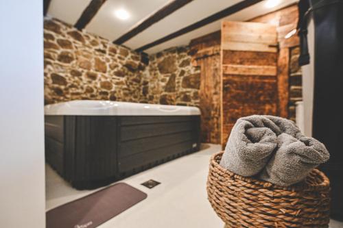 a bathroom with a tub and a basket with towels at HEDONIA in Fužine
