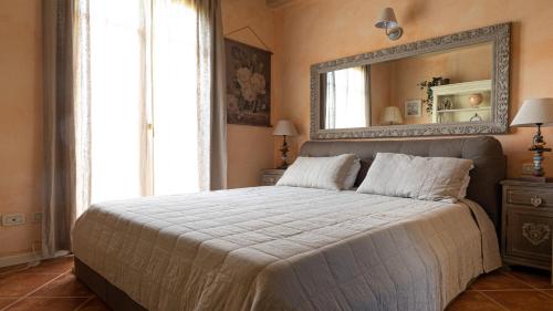 sypialnia z dużym łóżkiem i lustrem w obiekcie Garda Resort Village I Borghi w mieście Peschiera del Garda