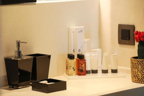 a bathroom counter with soap dispensers and a vase of flowers at Brilliance of Mykonos in Glastros