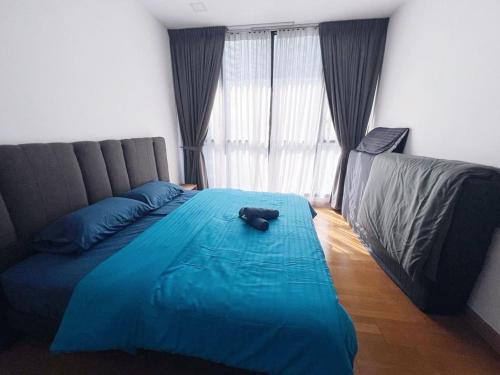 ein Schlafzimmer mit einem blauen Bett mit einer Katze auf dem Bett in der Unterkunft PROMO Connected Train 2 Bedroom ABOVE MALL 9 in Kuala Lumpur