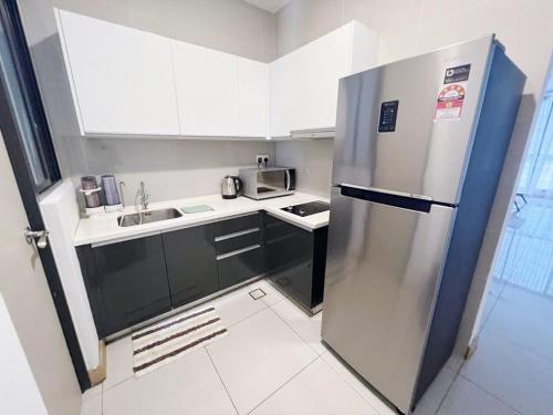 a small kitchen with a stainless steel refrigerator at PROMO Connected Train 2 Bedroom ABOVE MALL 9 in Kuala Lumpur