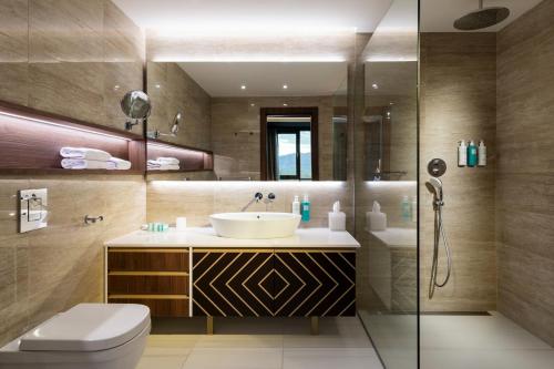 a bathroom with a sink and a toilet and a shower at Kings' Valley Medical & Spa Hotel in Kazanlŭk