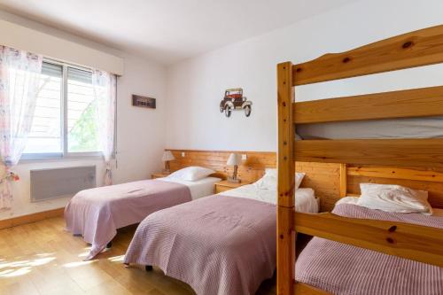1 Schlafzimmer mit 2 Etagenbetten und einem Fenster in der Unterkunft Maison Climatisée Vue Mer in Carry-le-Rouet