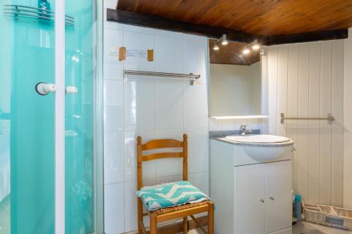 ein Badezimmer mit einem Waschbecken, einem Spiegel und einem Stuhl in der Unterkunft Maison Climatisée Vue Mer in Carry-le-Rouet