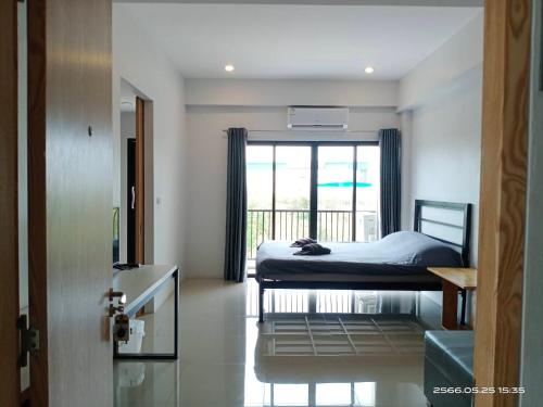 a bedroom with a bed and a window at NK place Phetchaburi in Ban Nong Som