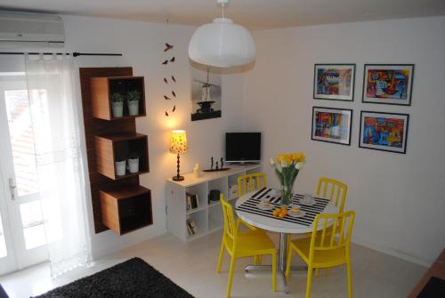 a dining room with a table and yellow chairs at Apartment Optimist in Makarska
