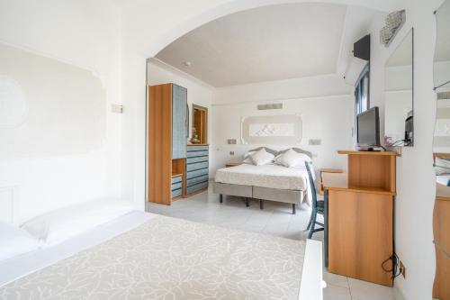a bedroom with a bed and a tv in a room at Royal Boutique Hotel NUOVA GESTIONE in Riccione