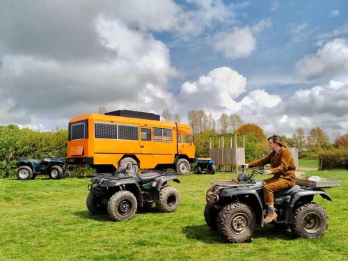 a man riding on a four wheeler in a field at Glamp in Style in a Converted Army Truck in Battle