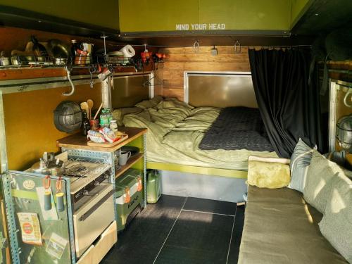 Cette petite chambre comprend un lit et une cuisine. dans l'établissement Glamp in Style in a Converted Army Truck, à Battle