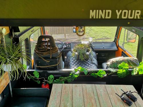 Une camionnette avec une table et des plantes à l'arrière dans l'établissement Glamp in Style in a Converted Army Truck, à Battle
