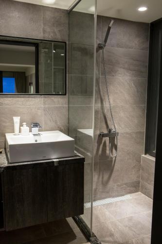 a bathroom with a sink and a shower at Something Easy Inn in Jiufen