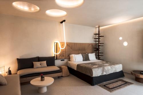 a bedroom with a bed and a couch at Brilliance of Mykonos in Glastros