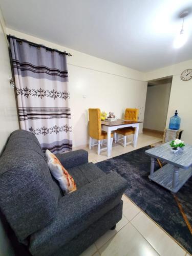 a living room with a couch and a table at 2 BR, TreasureTree Homes, Thika. in Thika