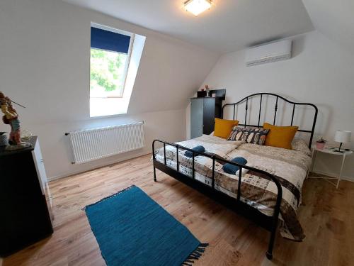 um quarto com uma cama e um tapete azul em Milla Apartmanok em Eger