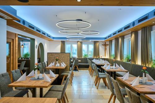 a restaurant with wooden tables and chairs and windows at Landhotel Geyer in Kipfenberg