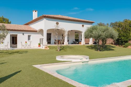 une maison avec une piscine en face d'une cour dans l'établissement Villa SARRAIRE, à Bormes-les-Mimosas