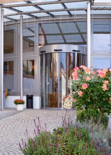 a glass building with flowers in front of it at Landhotel Geyer in Kipfenberg