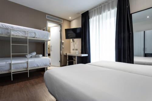 a bedroom with two bunk beds and a television at Petit Palace Triball in Madrid