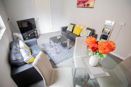 a living room with a couch and a table with flowers at The Royalty in Sunderland