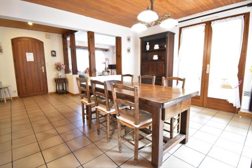 une salle à manger avec une table et des chaises en bois dans l'établissement La rose du pley - Seignosse spacieuse villa dans quartier calme et résidentiel, à Seignosse
