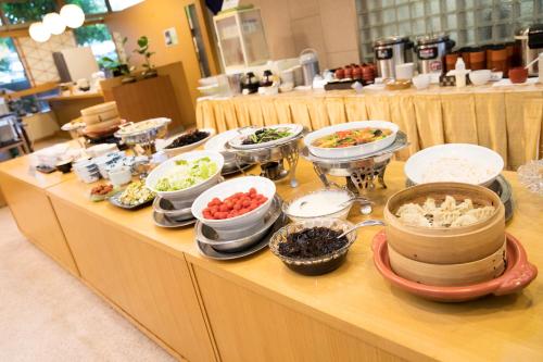 a buffet with many bowls of food on a table at Yokote Central Hotel in Yokote