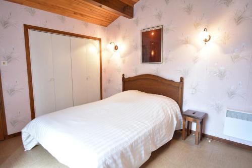 une chambre avec un lit blanc et un miroir dans l'établissement La rose du pley - Seignosse spacieuse villa dans quartier calme et résidentiel, à Seignosse