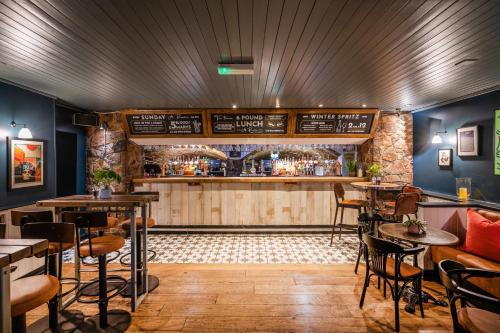 um restaurante com um bar com mesas e cadeiras em The Clifton Hotel Bristol em Bristol