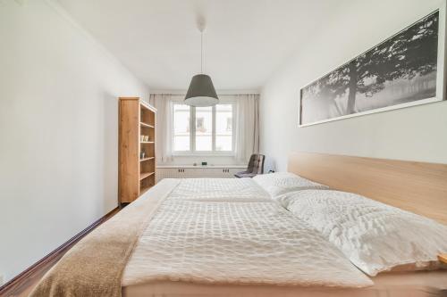 Cette chambre blanche dispose d'un grand lit et d'une fenêtre. dans l'établissement FeelHome-Karmeliterviertel-6 Gäste-WiFi-Smart TV, à Vienne