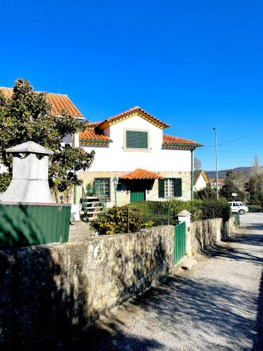 維塞烏的住宿－Casa Castenda，街道前有栅栏的白色房子