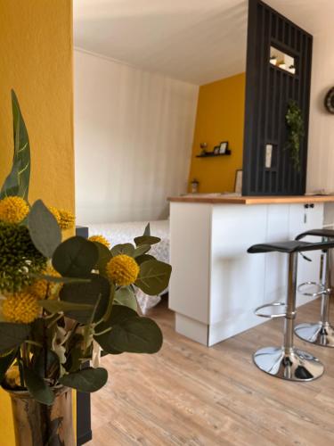 une cuisine avec des murs jaunes et un comptoir avec des tabourets dans l'établissement Le Jean Bart - Lille, à Lille