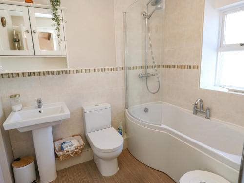 a bathroom with a toilet and a sink and a shower at Piccadilly View in Keighley