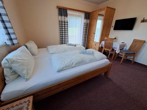 a large bed in a room with a table and chairs at Urlaub am Bauernhof Familie Kitting in Vorau