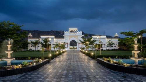 un gran edificio blanco con una pasarela por la noche en Hukamgarh - A Luxury Boutique Resort, en Nawalgarh