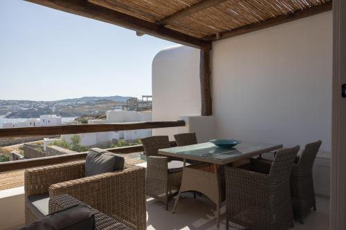 a dining room with a table and chairs on a balcony at Amaris Mykonian Residence in Ornos