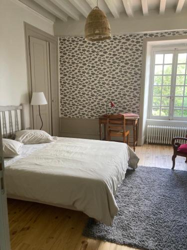 a bedroom with a bed and a desk in it at Les Tourellières 