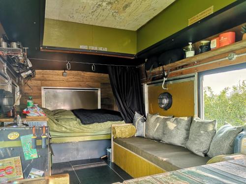 Cette chambre comprend un lit et un canapé. dans l'établissement Glamp in Style in a Converted Army Truck, à Battle