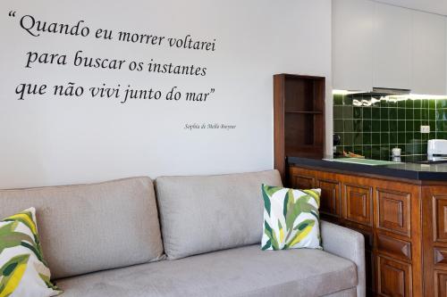 a couch in a living room with a quote on the wall at Casa Vasconcelos in Afife