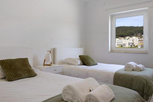a white room with two beds and a window at Casa Vasconcelos in Afife