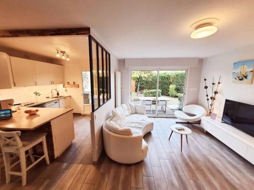 Una cocina y una sala de estar con un sofá y una mesa. en Le PATIO GARONNE maison 6 personnes, climatisé, Netflix, en Portet-sur-Garonne