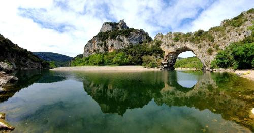 un viejo puente sobre un cuerpo de agua en Le Mas de l'Ibie Bleue, en Lagorce