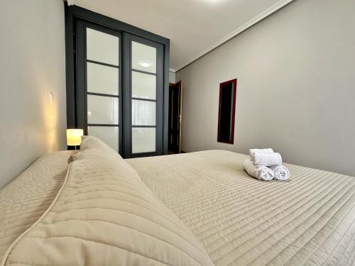 a bedroom with a large bed with two towels on it at Abad Paterno - 3008 in Santoña