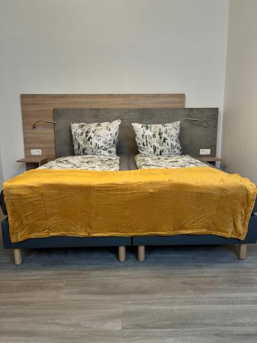 a bed with a yellow blanket on top of it at Spreewald - Idyll in Lübbenau