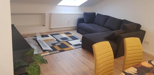 Joanna Apartment - Schwetzingen 3 في شفيتزينجين: غرفة معيشة مع أريكة زرقاء وكراسي صفراء