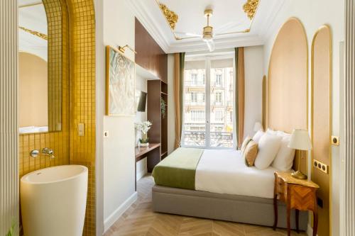 a bedroom with a bed and a tub and a window at Luxury 5 Bedroom 4 Bathroom - Louvre & Notre Dame in Paris