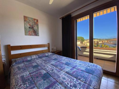 - une chambre avec un lit et une grande fenêtre dans l'établissement Estel, à L'Escala