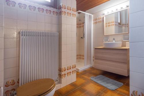 un baño con inodoro y lavabo en Residenza Lagorai, en Castello di Fiemme
