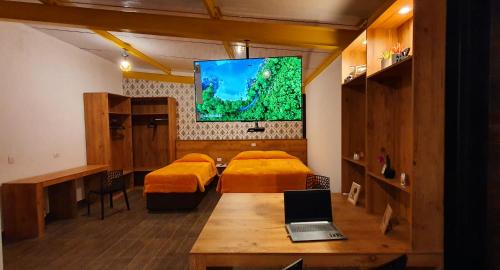 um quarto com 2 camas e um computador portátil numa mesa em Golden Forest Pousada em Campos de Jordão