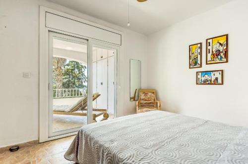 a bedroom with a bed and a sliding glass door at Sta Barbara 9 Canyelles Roses - Immo Barneda in Roses
