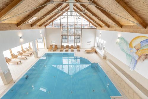 a swimming pool in a building with a large window at FerienPark Kreischberg by ALPS RESORTS in Sankt Lorenzen ob Murau